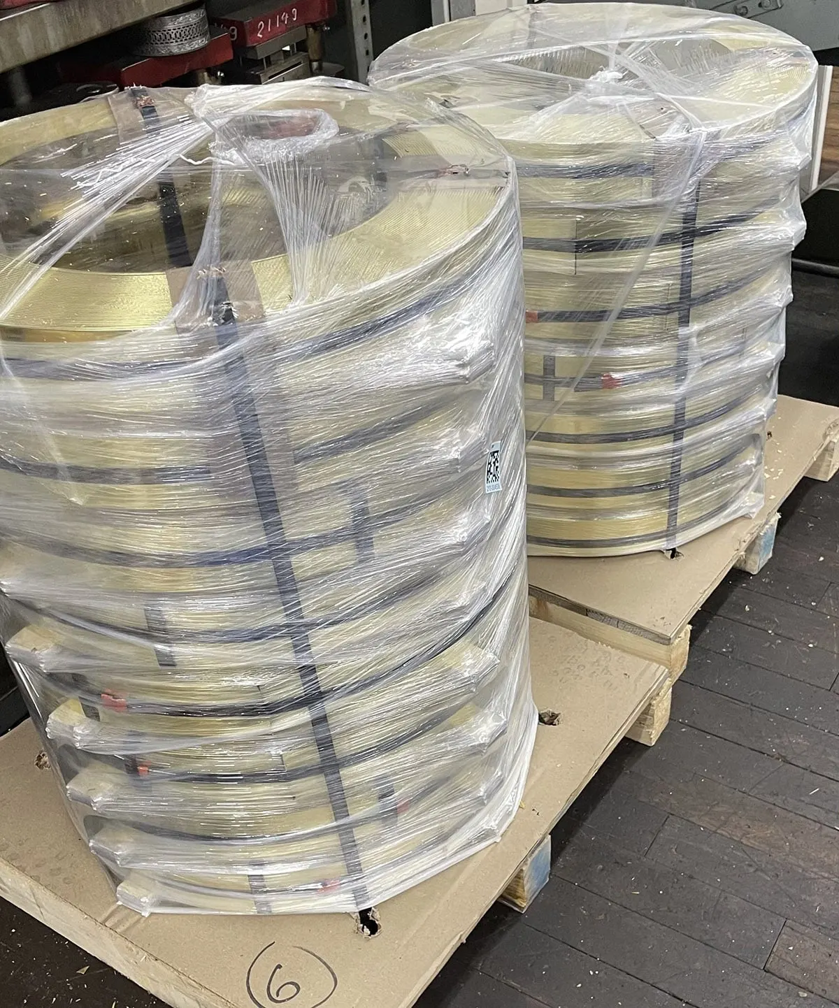 Shrink-wrapped coils of brass strip stock on a pallet