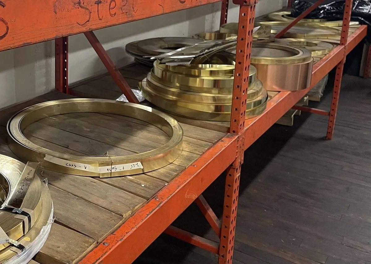 Coils of brass strip stored on wooden shelving