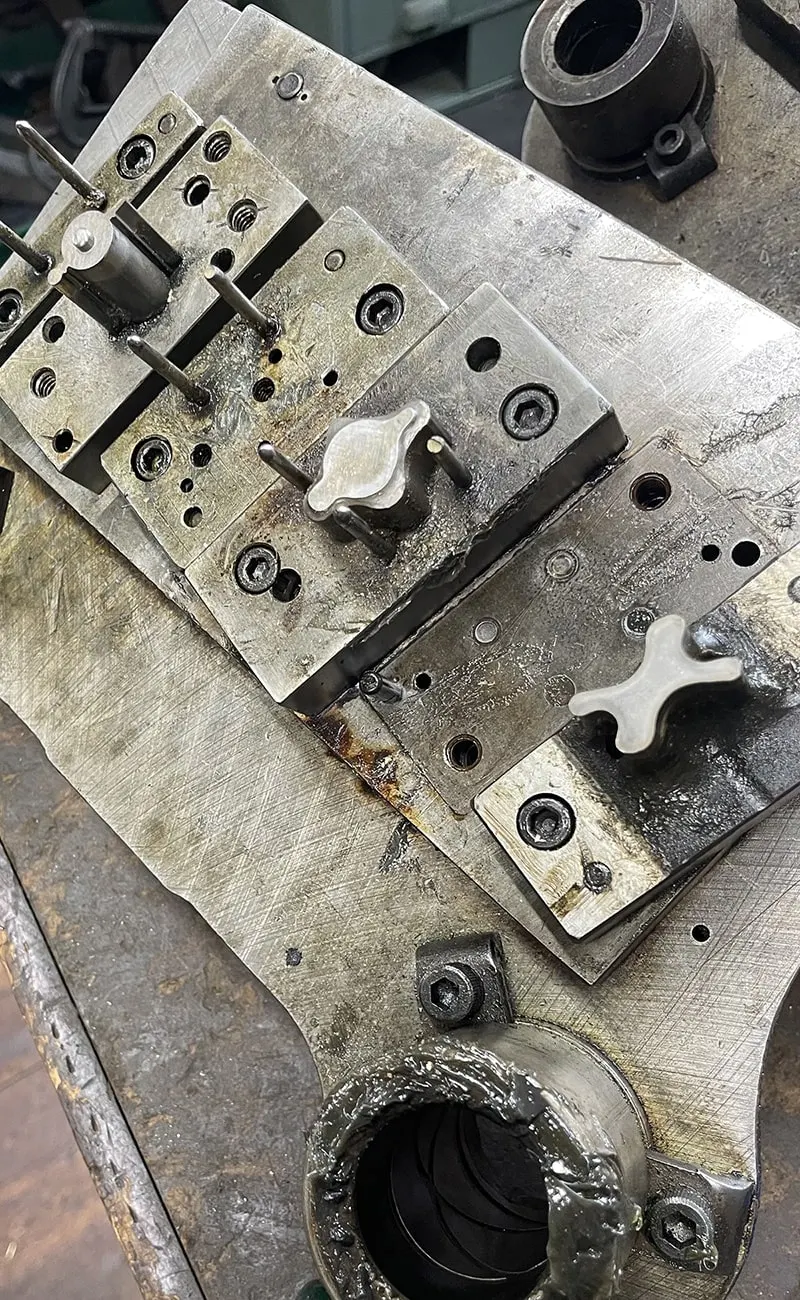 Close-up of a stamping die block with guide posts and fasteners