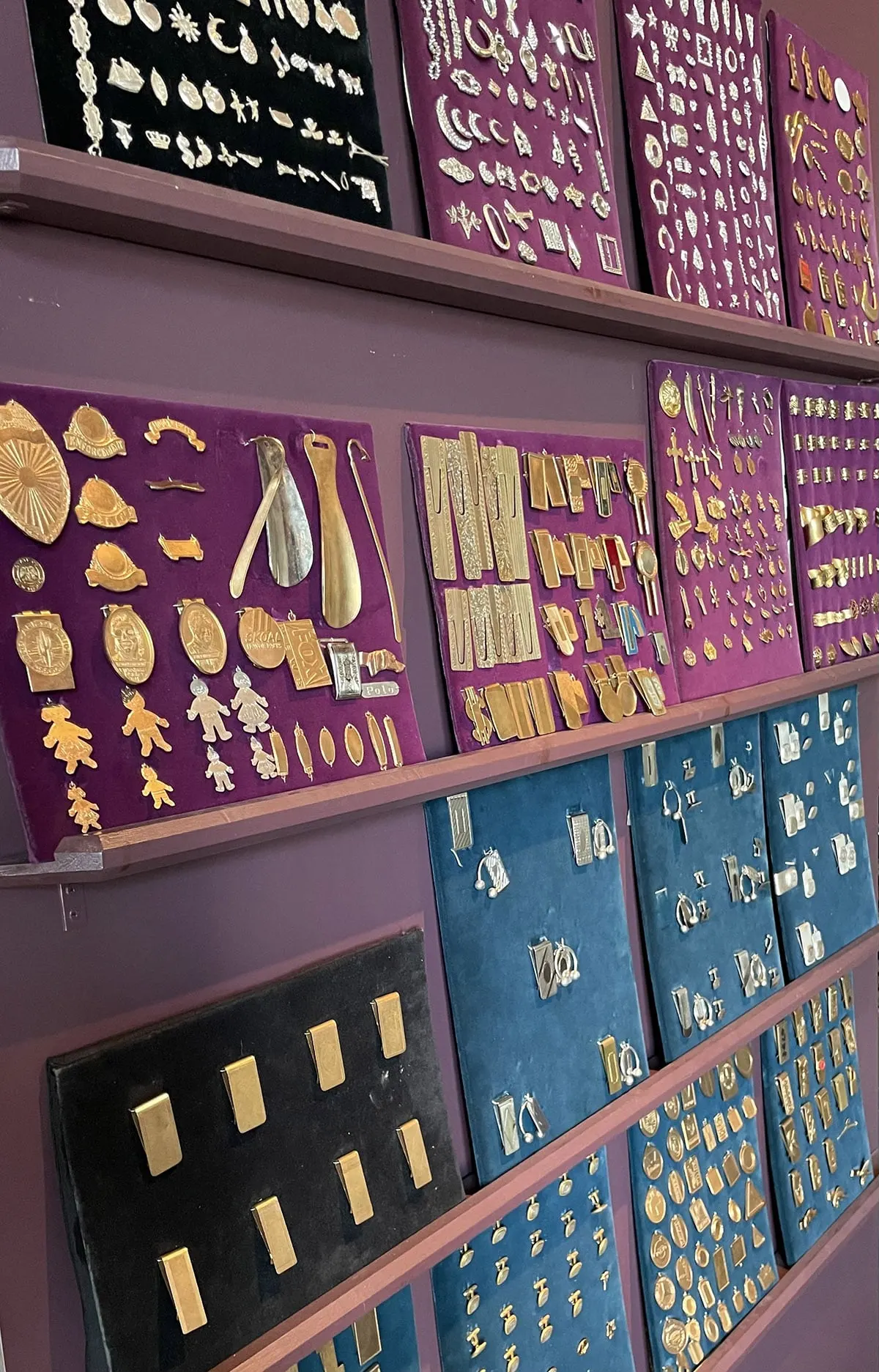 Sample boards covered with hundreds of stamped jewelry findings, mounted on purple and teal panels