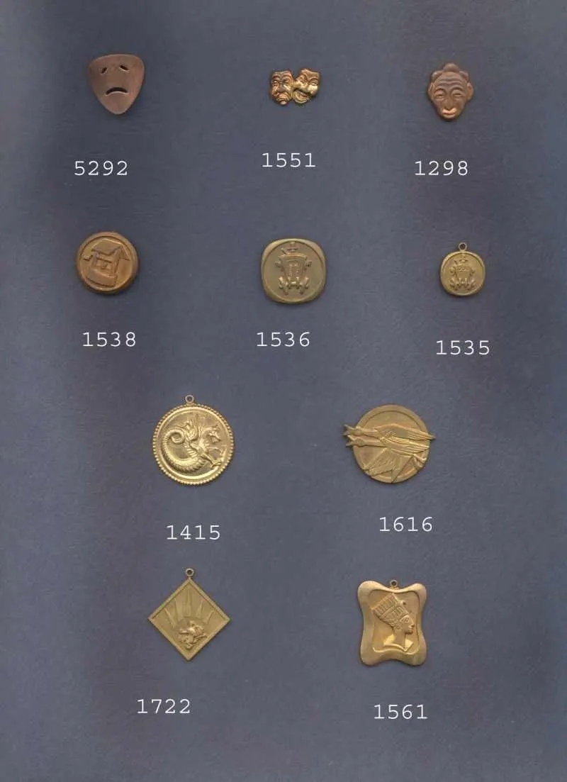 Catalog sheet of small stamped charms in brass and copper: theater masks, crests and round medallions, each with its part number