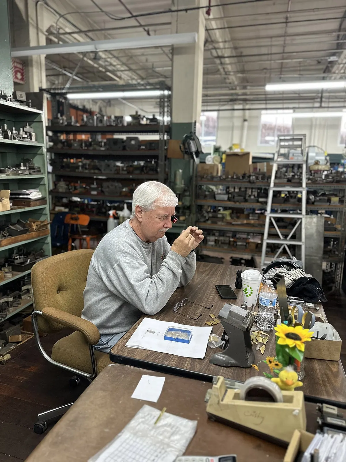 A Mel-Co-Ed employee working at a desk on the shop floor